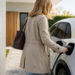 Rangée de voitures électriques neuves garées devant une concession automobile moderne sous ciel dégagé