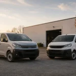 Rangée de fourgonnettes utilitaires blanches garées dans un parc de vente de véhicules d'occasion