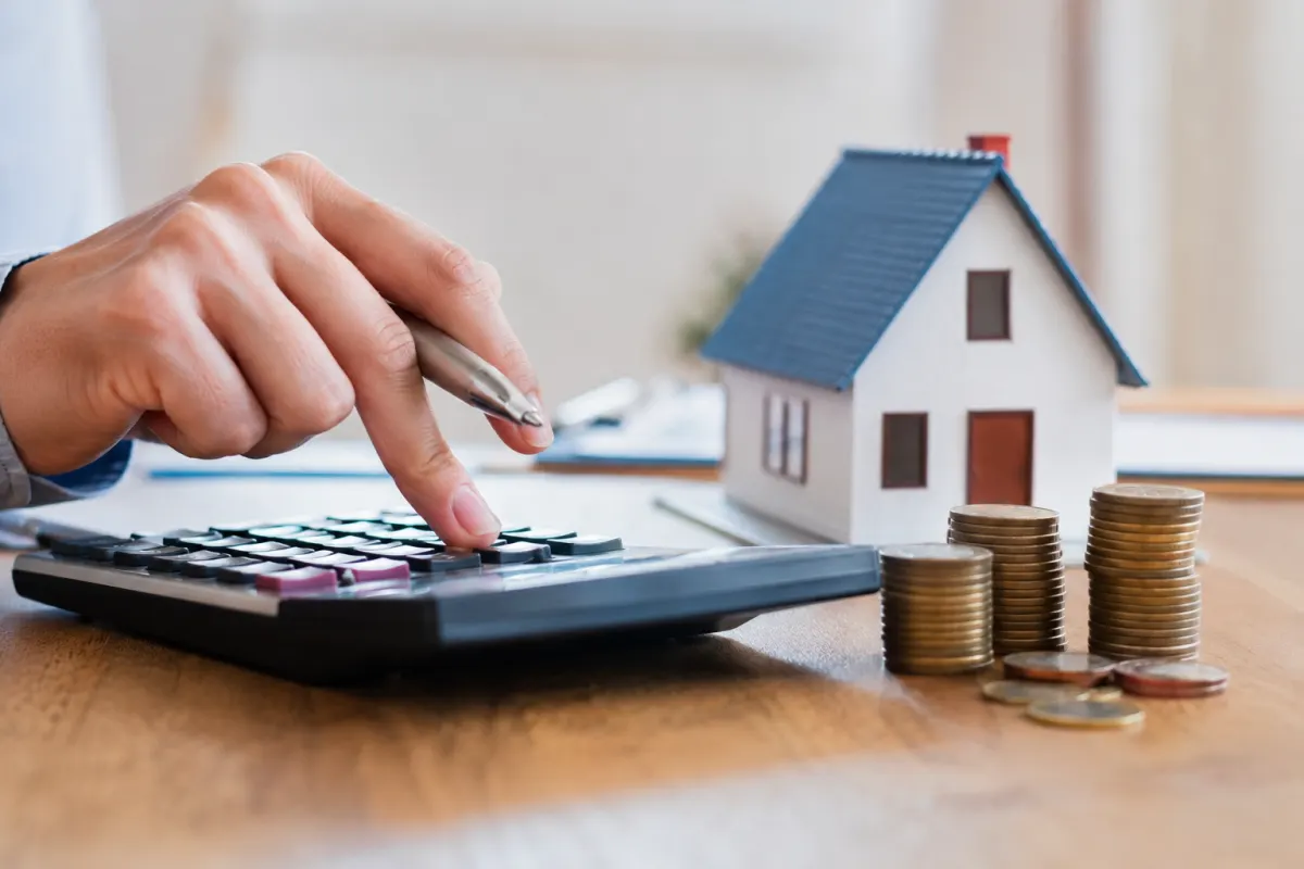 Prévisions sur le taux immobilier en 2027 et impact sur votre budget Gros plan sur les mains d'un emprunteur signant une offre de prêt bancaire imprimée