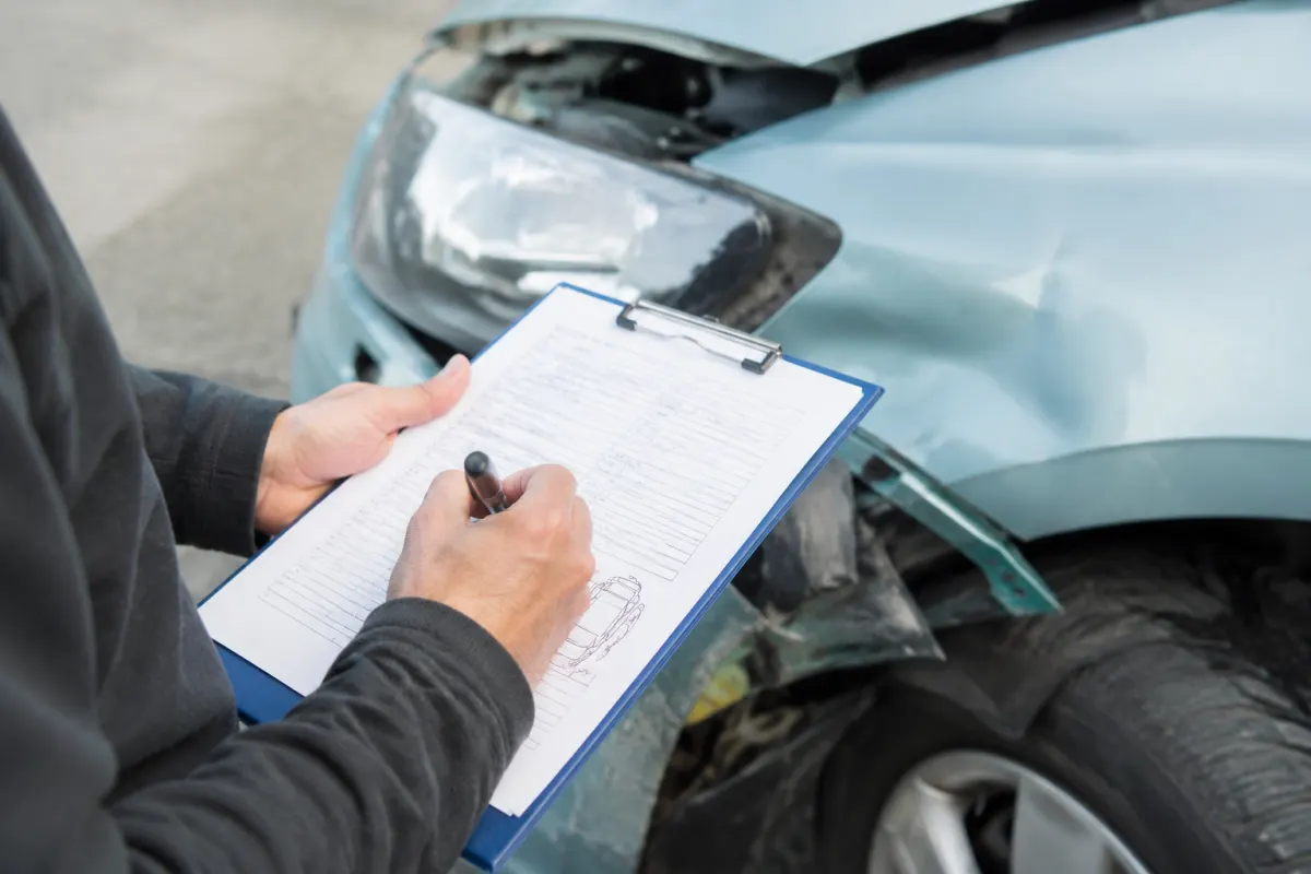 Gros plan sur les clés d'une voiture posées sur un rapport d'expertise automobile imprimé