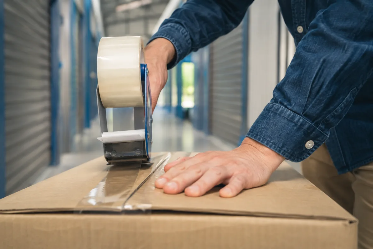 Main fermant un cadenas en acier sur un cadenas de box de stockage sécurisé