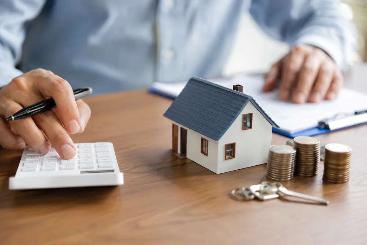 Tout comprendre sur le rachat de crédit pour propriétaire et ses vrais coûts Gros plan sur les clés d'une maison posées sur un dossier bancaire d'emprunt immobilier